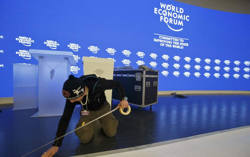 A technician is setting up a carpet on the stage at the congress center where the World Economic Forum will take place later this week in Davos, Switzerland, Monday, Jan 18, 2016. 