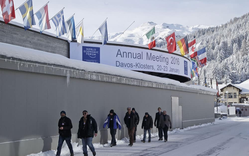 People pass by the congress center where the World Economic Forum will take place later this week in Davos, Switzerland, Monday Jan 18, 2016.