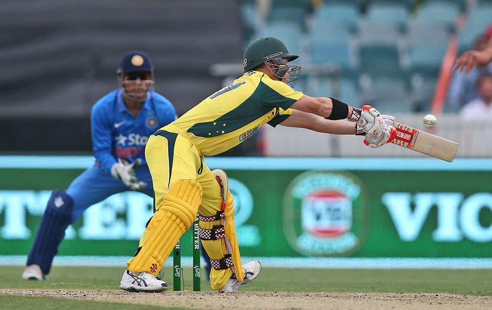 David Warner stretches to play a shot as a wide ball is thrown from Indian bowler Rishi Dhawan during their One Day International cricket match in Canberra, Australia.