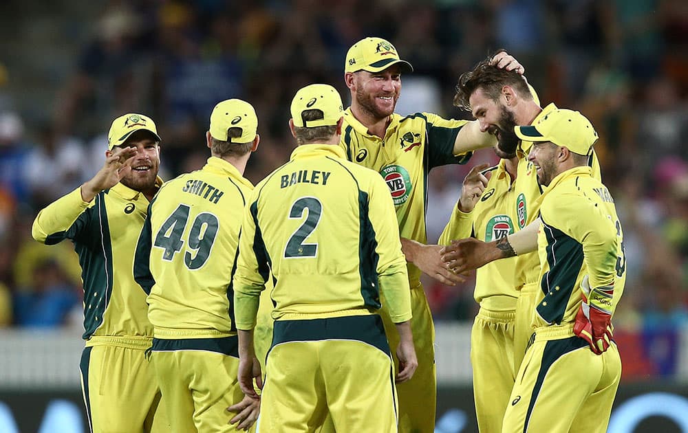 Australia's Kane Richardson is congratulated by teammates after taking a wicket during their One Day International cricket match against India in Canberra, Australia.