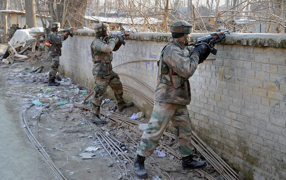 Army personnel take positions towards the house where militants were hiding during an encounter at Naina village of Pulwama district in South Kashmir.