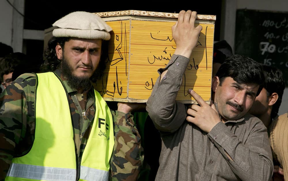 Pakistani volunteers carry a coffin containing the body of an attack victim, in Charsadda town.