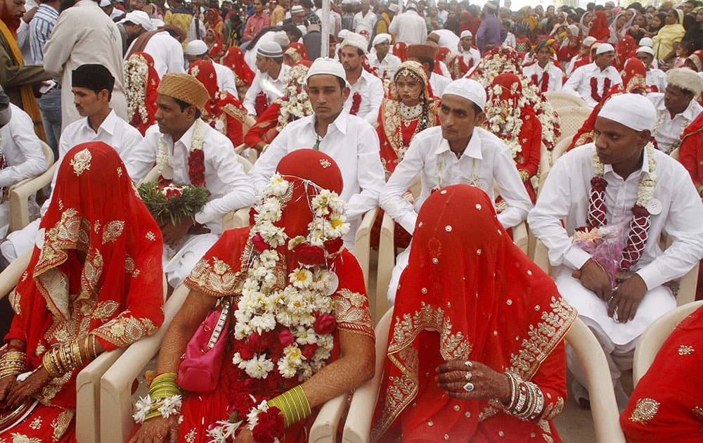Muslim brides and their grooms wait for the start of a mass marriage ceremony in Ahmedabad.