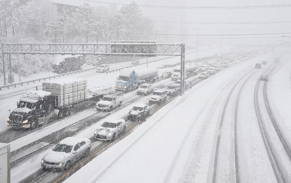 Snow slows down traffic on Interstate 40, in Nashville, Tenn. A blizzard menacing the Eastern United States started dumping snow in Virginia, Tennessee and other parts of the South on Friday as millions of people in the storm's path prepared for icy roads, possible power outages and other treacherous conditions.