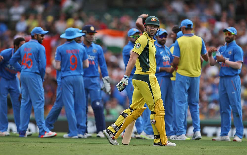 Australia's Shaun Marsh walks past Indian players as they celebrate taking his wicket during their one-day international cricket match in Sydney.