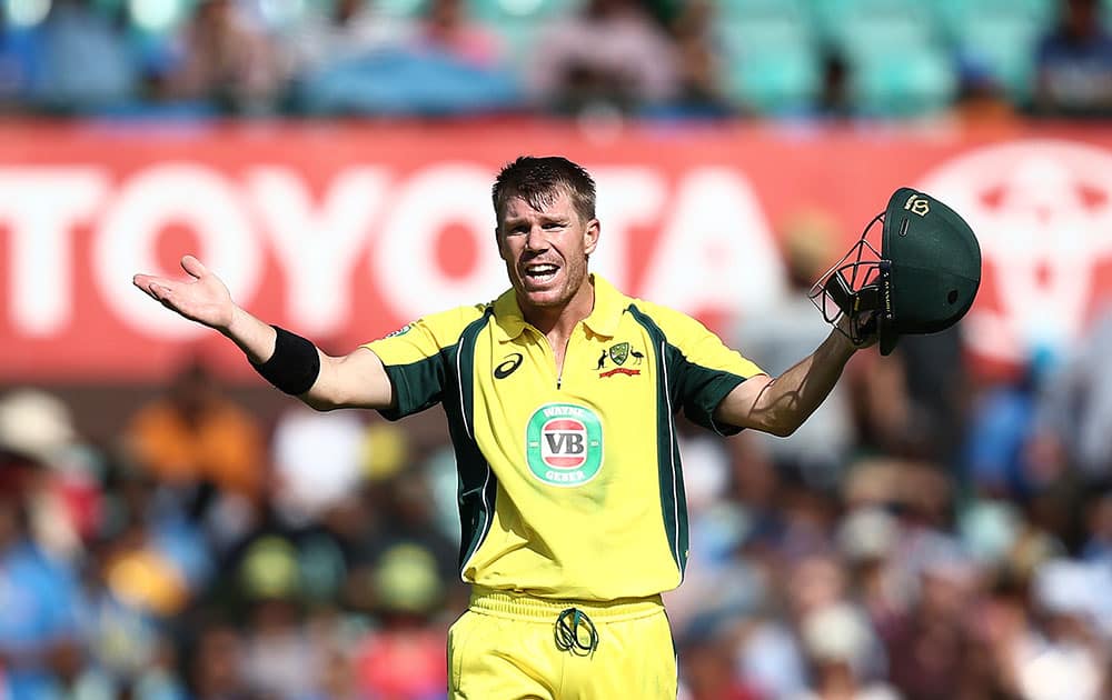 Australia's David Warner calls for a new helmet during their one-day international cricket match against India in Sydney, Australia.