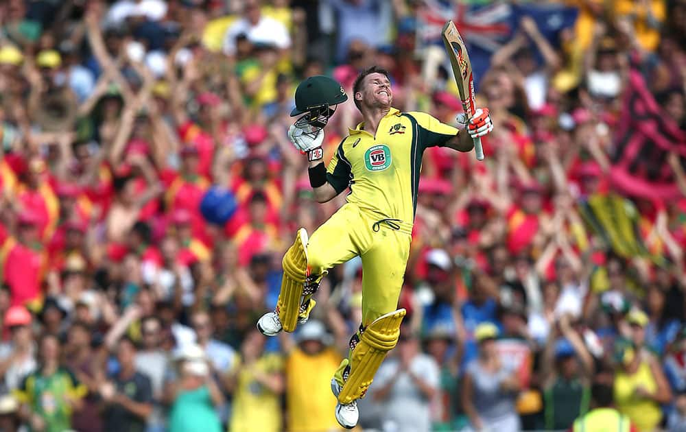 Australia's David Warner leaps into the air as he celebrates after hitting a century against India during their One Day International cricket match in Sydney.