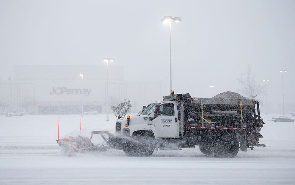 A snow plow truck makes its way down Electric Road in southwest Roanoke County past Tanglewood Mall, in Roanoke, Va.