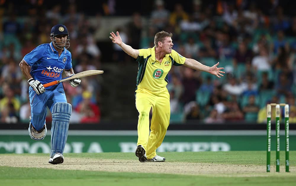 MS Dhoni, left, runs between the wicket as Australia's James Faulkner appeals for his wicket during their One Day International cricket match in Sydney, Australia.