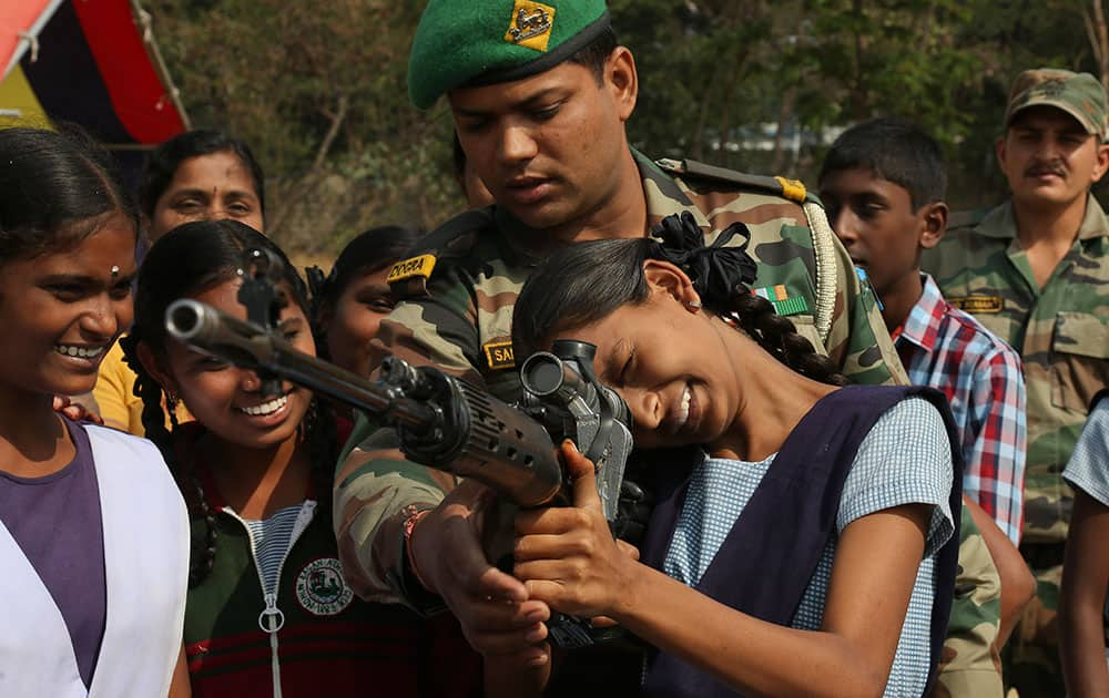 Students listen as an Indian army soldier demonstrates the use of a weapon at a display of arms and equipment by the Indian army at Bison Polo grounds at Secunderabad in Hyderabad, India.