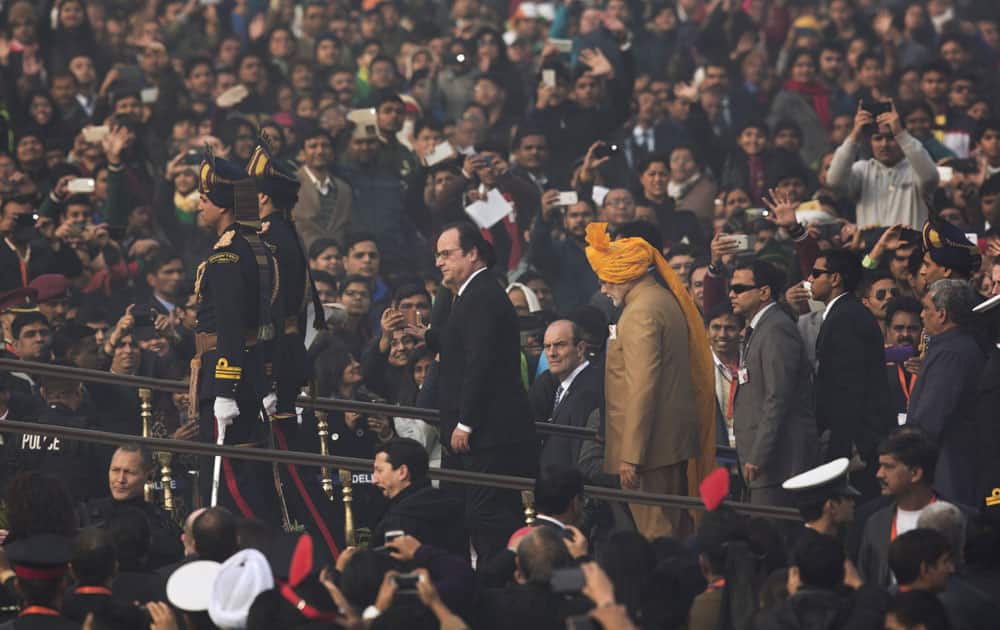 French President Francois Hollande, left, is accompanied by Indian Prime Minister Narendra Modi as he arrives to watch the Republic Day parade in New Delhi.