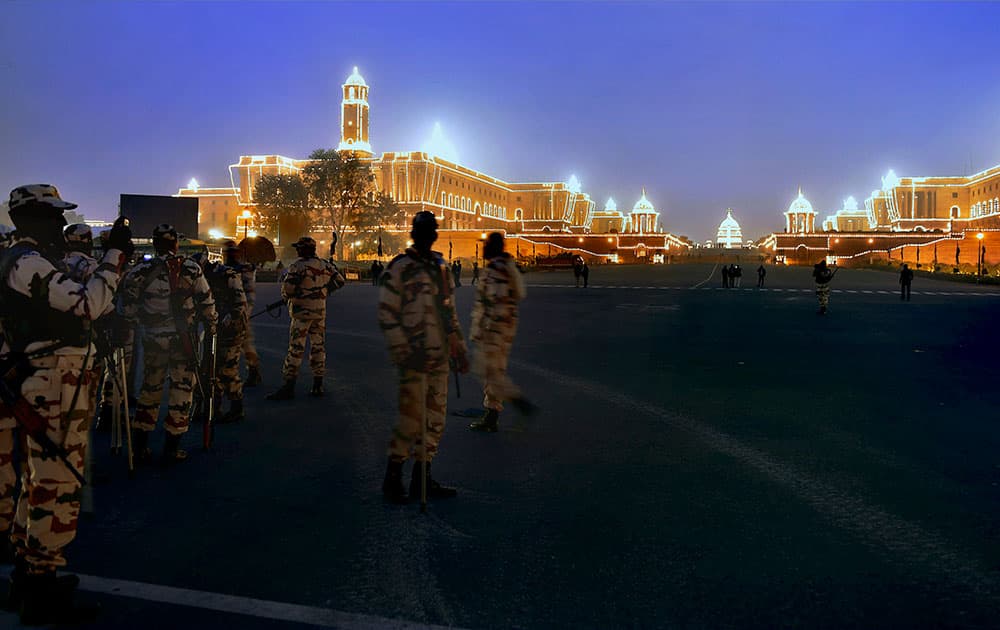 Securitymen stand guard near illuminated North Block and South Block in New Delhi on Tuesday on the occasion of Republic Day. 