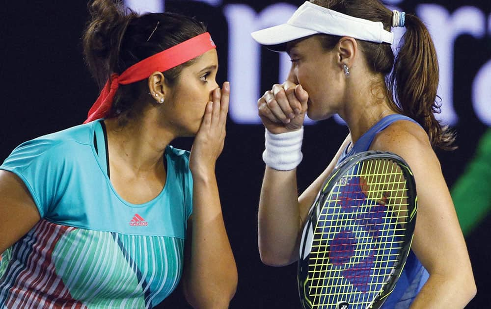 Martina Hingis of Switzerland and Sania Mirza of India talk between games in their semifinal against Julia Goerges of Germany and Karolina Pliskova of the Czech Republic at the Australian Open tennis championships in Melbourne.