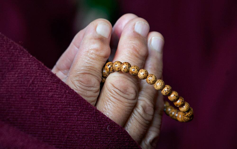 An exiled Tibetan nun prays for the longevity of their spiritual leader, the Dalai Lama, in Dharmsala, India.