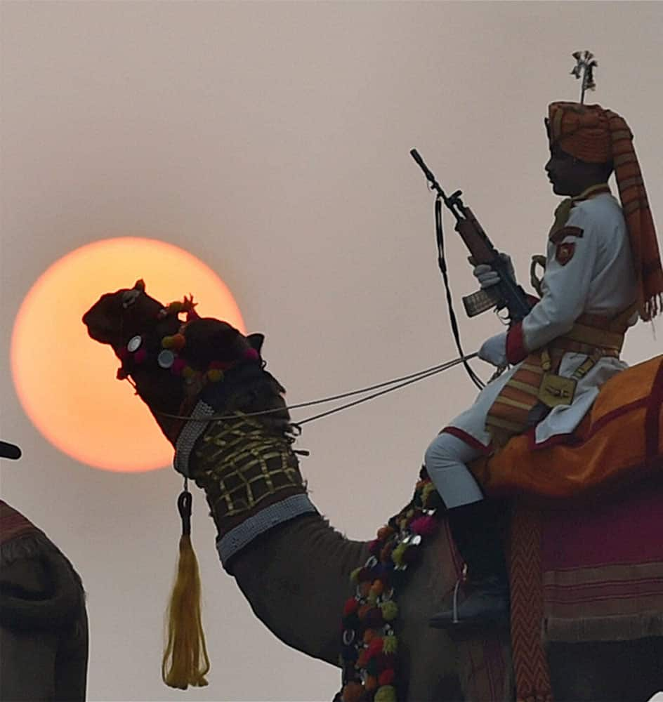 BSF soldiers mounted on camels participate in rehearsal for the Beating Retreat ceremony as the Sun sets in the background, in New Delhi.