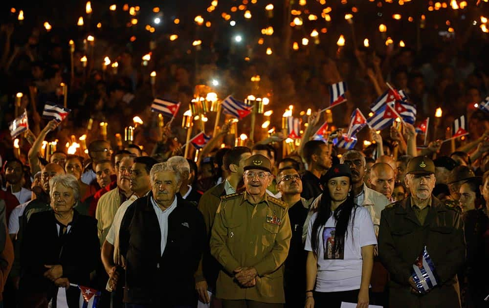 Cuba´s President Raul Castro, center front, along with Uruguays former President Jose Mujica, his wife Sen. Lucia Topolansky, left, President of University Students Federation Jennifer Bello and Revolutionionary Commander Ramiro Valdes, front right, take part in a march with torches in a procession, marking the 163rd anniversary of the birth of Cubas national independence hero Jose Marti, in Havana, Cuba.