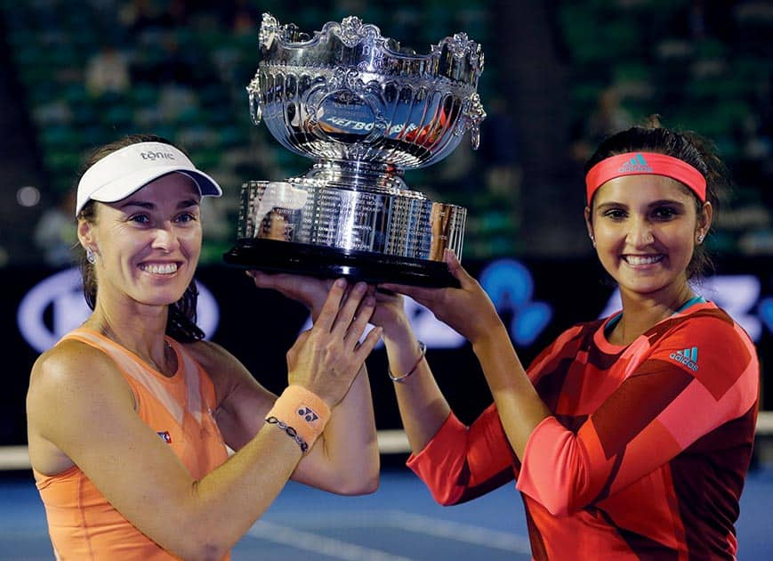 Martina Hingis, of Switzerland and Sania Mirza of India hold their trophy aloft after defeating Czech Republic’s Andrea Hlavackova and Lucie Hradecka in the women's doubles final at the Australian Open tennis championships in Melbourne.