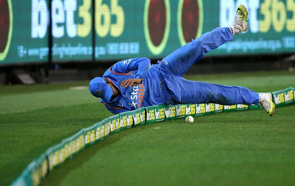 Umesh Yadav stops the ball at the boundary during their T20 cricket match against Australia in Melbourne.