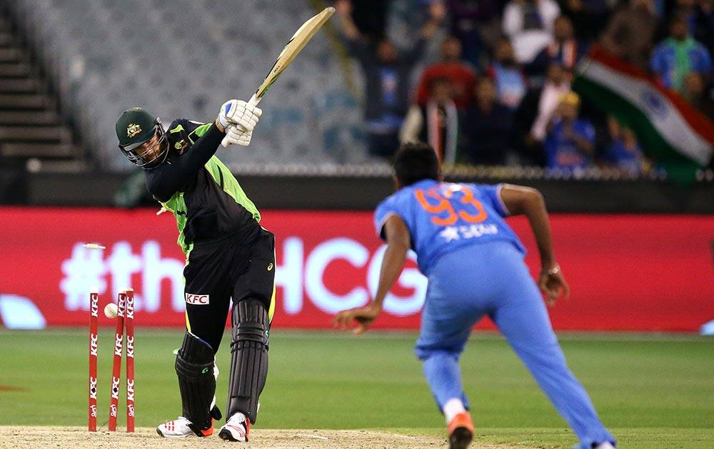 Jasprit Bumrah, right, bowls out Australia's Andrew Tye during their T20 cricket match in Melbourne.