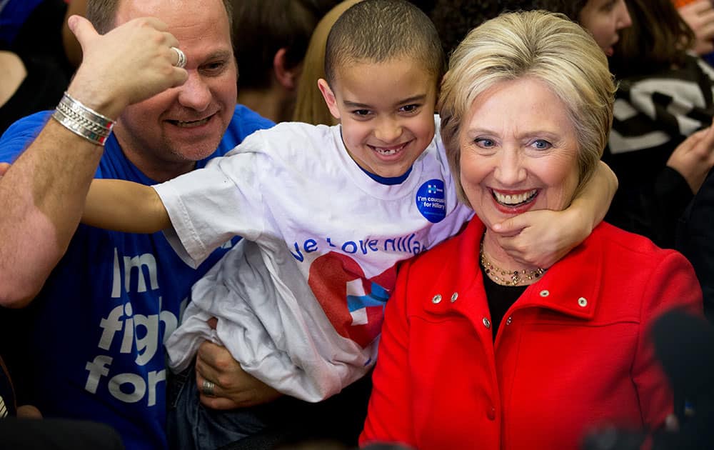 Democratic presidential candidate Hillary Clinton is embraced by a young member of the audience as they pose for a photograph at a rally at Washington High School in Cedar Rapids, Iowa.