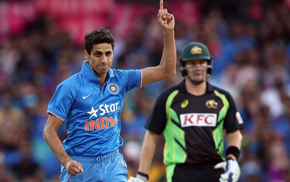 Indian bowler Ashish Nehra points up to the air as he celebrates taking the wicket of Australia's Usman Khawaja during their T20 International cricket match in Sydney, Australia.