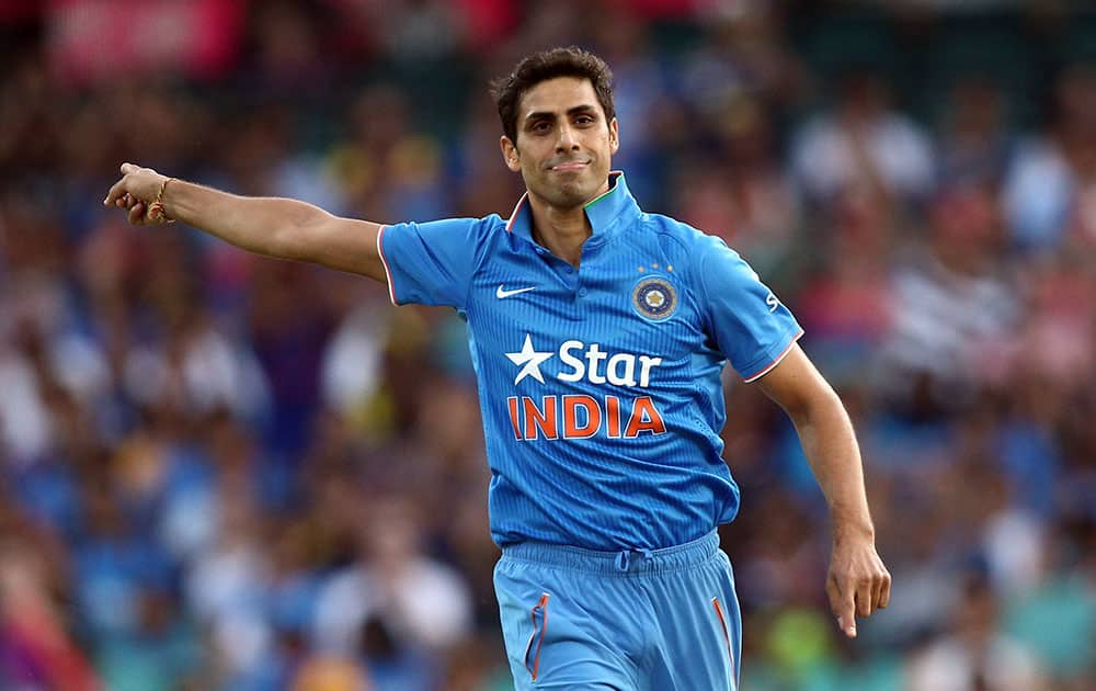 Indian bowler Ashish Nehra points behind as he celebrates taking the wicket of Australia's Usman Khawaja during their T20 International cricket match in Sydney, Australia.