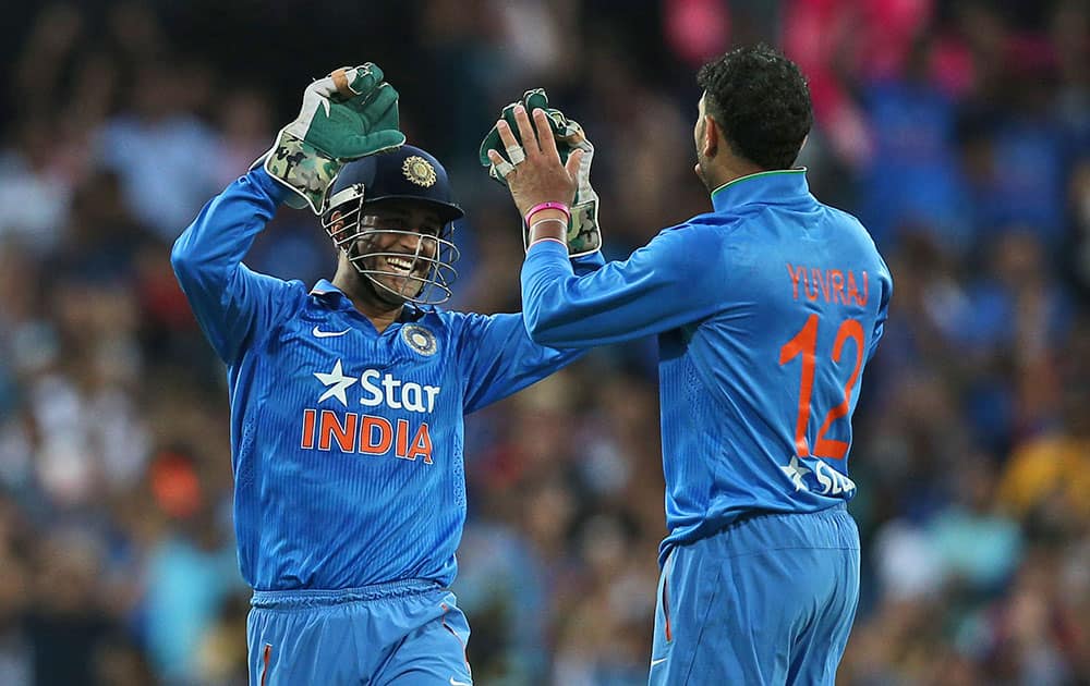 Indian bowler Yuvraj Singh, right, celebrates with MS Dhoni after taking the wicket of Australia's Glenn Maxwell during their T20 International cricket match in Sydney, Australia.