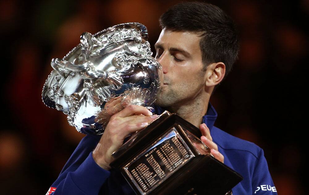 Novak Djokovic of Serbia kisses his trophy after defeating Andy Murray of Britain in the men's singles final at the Australian Open tennis championships in Melbourne.