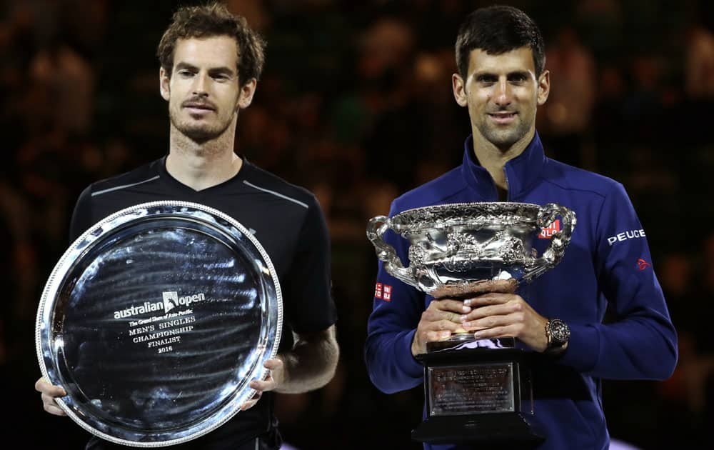 Novak Djokovic, right, of Serbia holds his trophy after defeating Andy Murray, left, of Britain in the men's singles final at the Australian Open tennis championships in Melbourne.