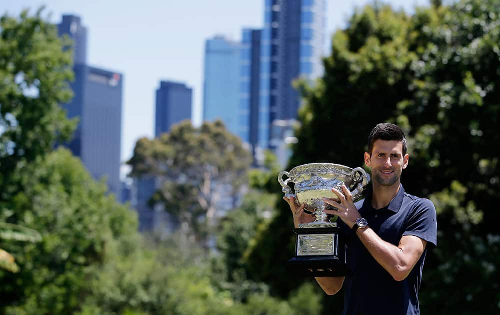 Serbia's Novak Djokovic poses for photos with his Australian Open trophy at Government House in Melbourne, Australia.