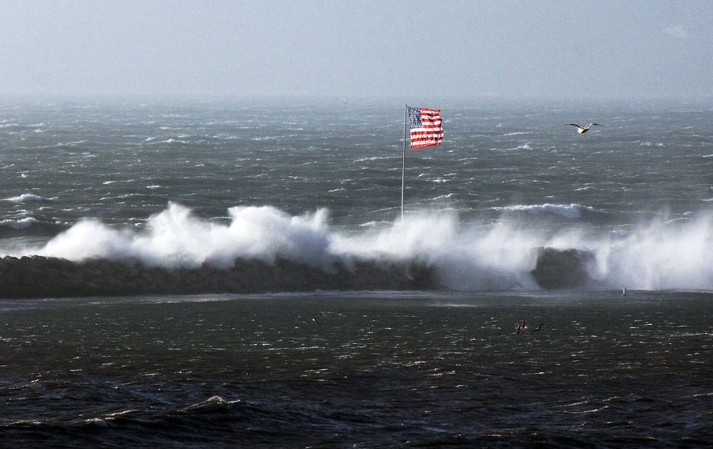 Fierce winds trailing a daylong storm churn the Pacific Ocean, send waves over the breakwater at the Los Angeles community of Marina Del Rey, Calif.