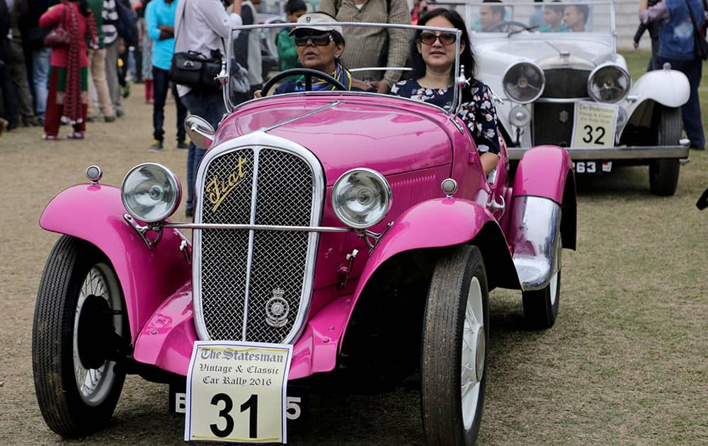 A woman drives a 1933 Fiat car during the Statesman vintage & classic car rally in Kolkata.