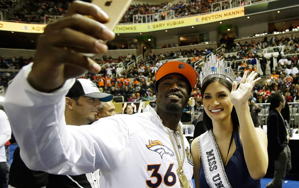 Miss Universe Pia Alonzo Wurtzbach poses with Denver Broncos cornerback Kayvon Webster during Opening Night for the NFL Super Bowl 50 football game.