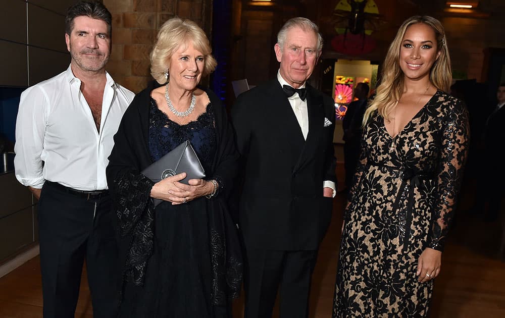 Britain's Prince Charles, second right, and Camilla, the Duchess of Cambridge, second left, pose with Simon Cowell, left, and British singer Leona Lewis during a reception and dinner for supporters of the British Asian Trust, at the Natural History Museum in London.