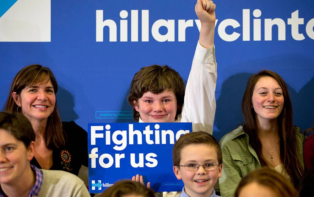 Dylan Swain, 14, of Hampton, N.H., raises his fist in the air as Democratic presidential candidate Hillary Clinton greets the crowd at the end of her event in Hampton, N.H.