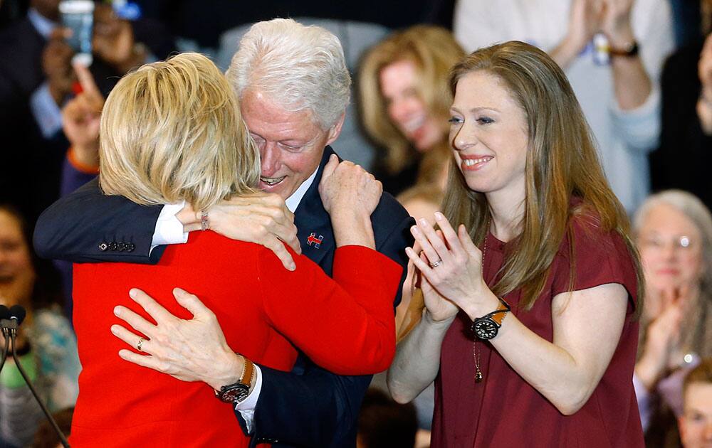 Democratic presidential candidate Hillary Clinton hugs former President Bill Clinton alongside their daughter Chelsea during a caucus night rally at Drake University in Des Moines, Iowa.