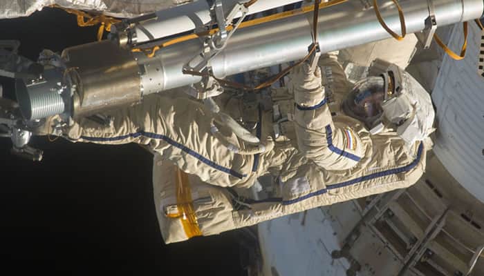Russians go spacewalking to collect experiments, test glue