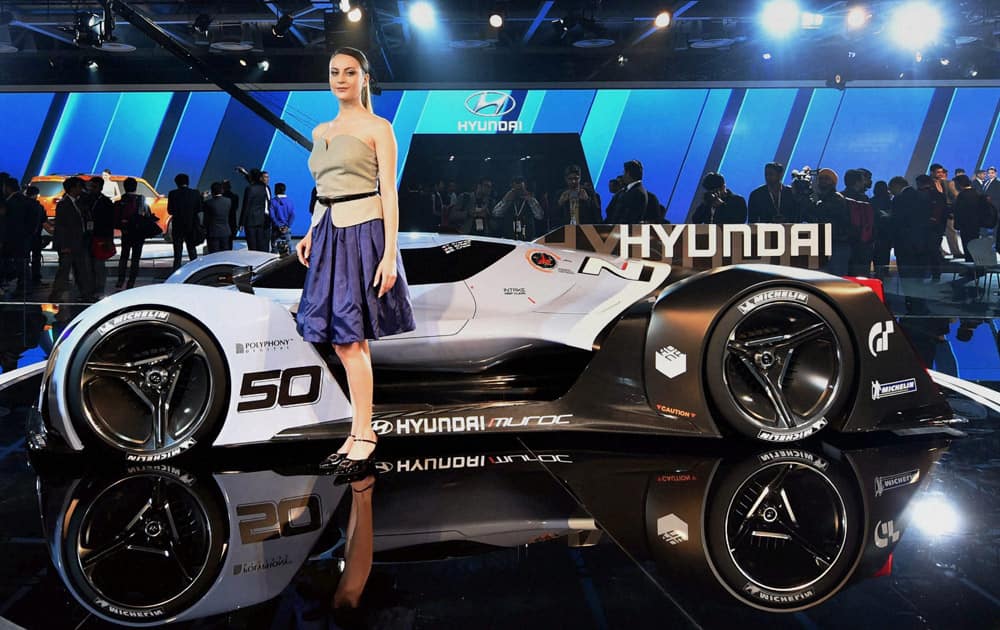 A model poses in front of a sports car displayed at the Hyundai stall at Auto Expo 2016 in Greater Noida.

