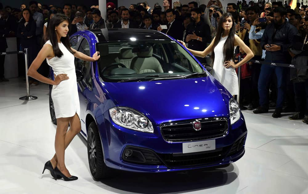 Models pose with Fiat Motors Linea at Auto Expo 2016 in Greater Noida on Thursday.