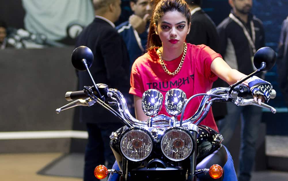 An Indian model sits on a Triumph motorcycle during the Auto Expo, in Greater Noida, near New Delhi.
