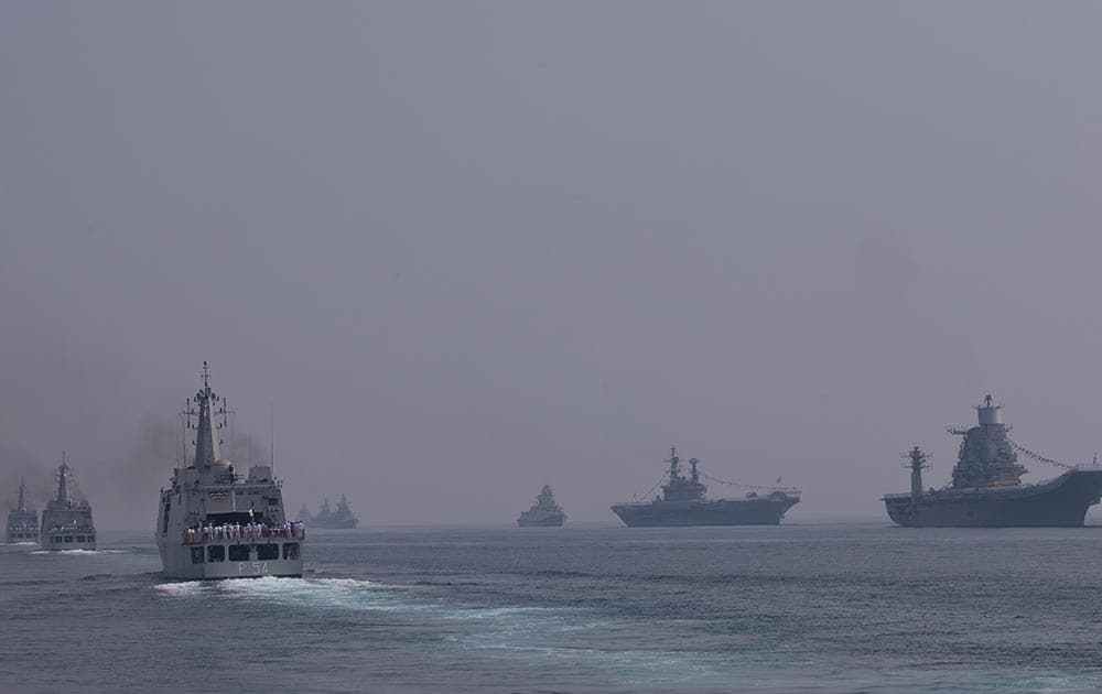 A column of Indian naval ships on the left, with the first ship carrying Indian President Pranab Mukherjee, passes by Indian aircraft carriers during the International Fleet Review in Vishakapatnam.