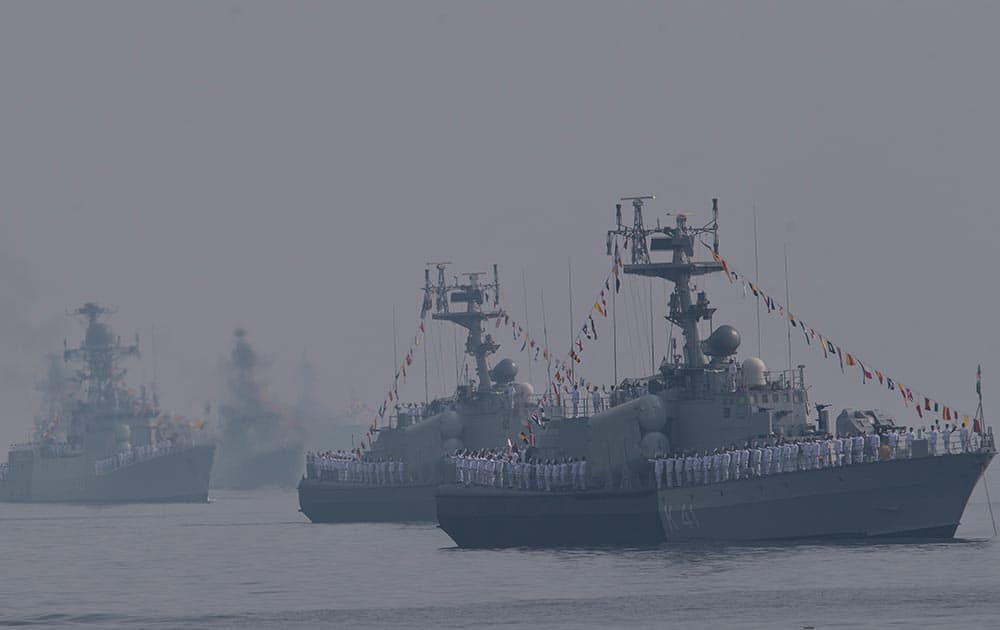 Indian sailors on a veer class corvette take their caps in their hand as they salute the Indian President Pranab Mukherjee, during the International Fleet Review in Vishakapatnam.