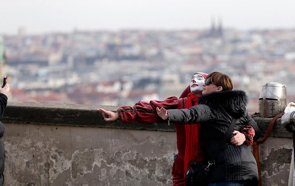 Woman has her picture taken with a man in a jester costume in Prague, Czech Republic.