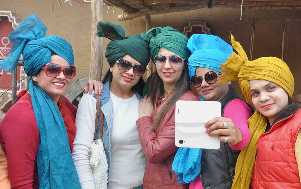 Girls take selfie during Surajkund International Crafts Mela in Faridabad.