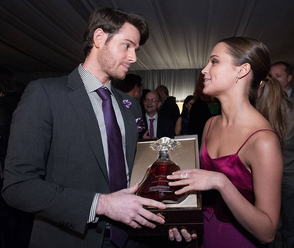 Frank Larrazaleta, Prestige Range Brand Educator at Moët Hennessy USA, presents a bottle of Hennessy Paradis Impérial to actress Alicia Vikander after she received the prestigious Virtuoso Award.