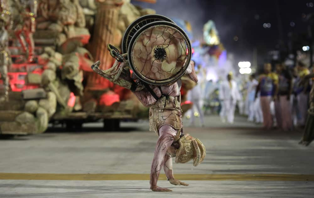 A performer on a wheelchair from Uniao da Ilha samba school, walks on his hands during the Carnival celebrations at the Sambadrome in Rio de Janeiro, Brazil.