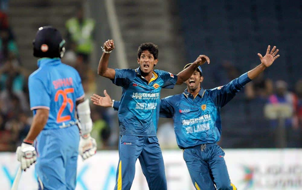 Sri Lanka cricket player Kasun Rajita, centre, celebrates after taking Indian player Ajinkya Rahane's wicket during first T20 match between India and Sri Lanka in Pune.