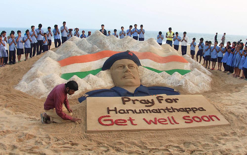 Renowned sand artist Sudarsan Pattnaik creates a sand sculpture of Lance Naik Hanumanthappa Koppad for his speedy recovery at Puri sea beach.