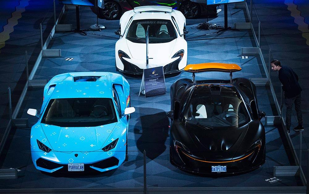 A man looks over vehicles at the 2016 Canadian International Autoshow in Toronto.