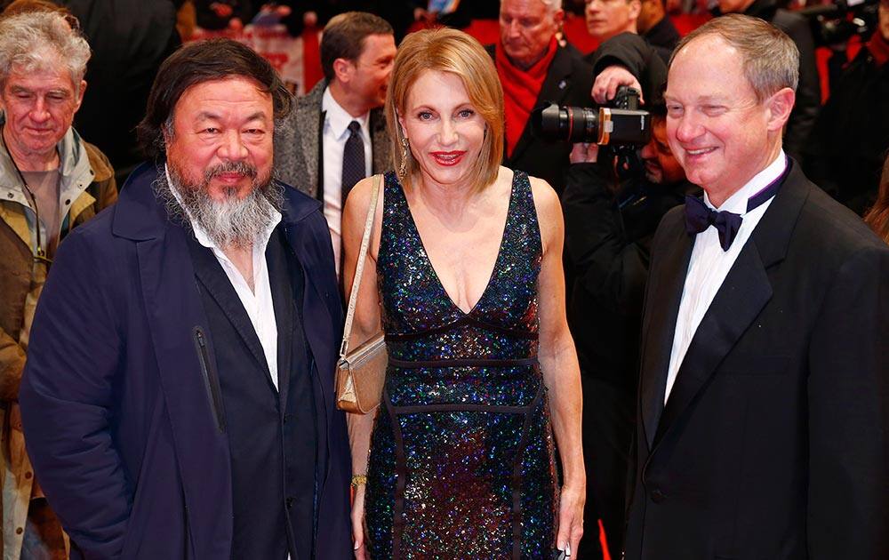 Chinese artist Ai Weiwei, left, Kimberly Marteau Emerson, wife of the American Ambassador to Germany John Emerson, right, pose for a photograph at the red carpet for 'Hail, Caesar!' the opening film of the 2016 Berlinale Film Festival in Berlin, Germany.